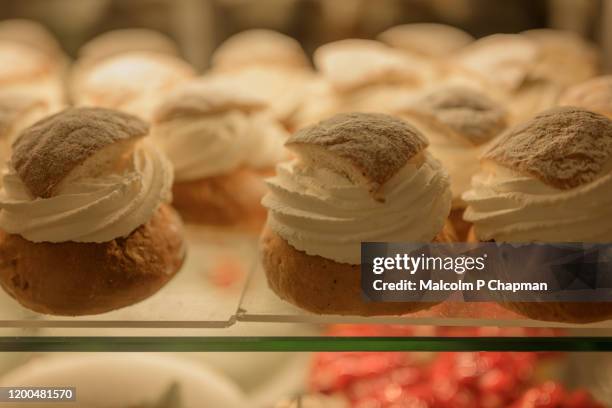 semla (plural semlor) are cream buns, with almond paste, traditionally eaten on, or before, shrove tuesday in sweden / scandinavia. also known as fastlagsbulle, laskiaispulla, vastlakukkel, fastelavnsbolle - pancake day - fotografias e filmes do acervo