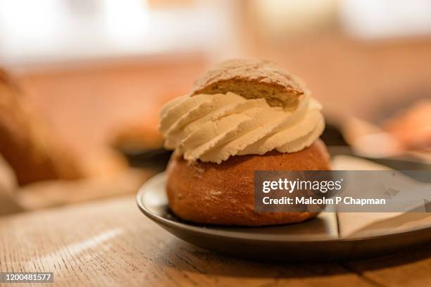 semla (plural semlor) are cream buns, with almond paste, traditionally eaten on, or before, shrove tuesday in sweden / scandinavia. also known as fastlagsbulle, laskiaispulla, vastlakukkel, fastelavnsbolle - whip cream cake fotografías e imágenes de stock