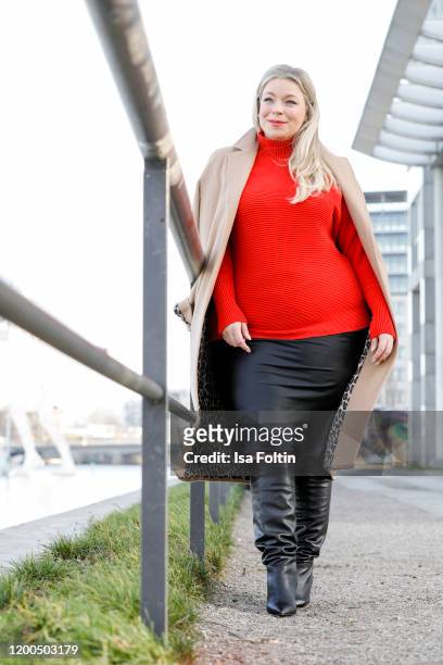 German presenter, curvy model and plus size influencer wearing a red pullover by Riani, a black skirt by Max Mara, a beige coat Persona by Marina...