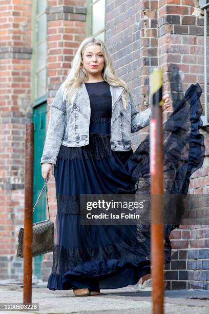 German presenter, curvy model and plus size influencer wearing a dark blue dress with ruffles and a jeans jacket by Marina Rinaldi, a Gucci purse and...