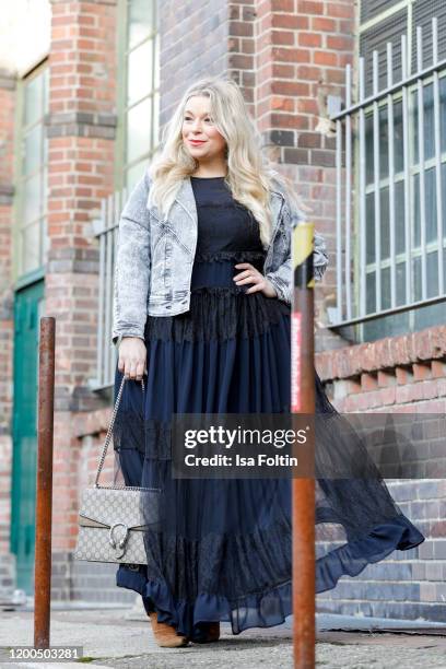 German presenter, curvy model and plus size influencer wearing a dark blue dress with ruffles and a jeans jacket by Marina Rinaldi, a Gucci purse and...