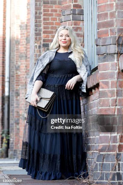 German presenter, curvy model and plus size influencer wearing a dark blue dress with ruffles and a jeans jacket by Marina Rinaldi, a Gucci purse and...