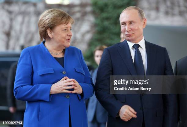 German Chancellor Angela Merkel greets Russian President Vladimir Putin as he arrives for an international summit on securing peace in Libya at the...