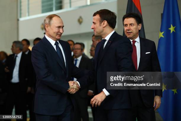 French President Emmanuel Macron greets Russian President Vladimir Putin as they arrive for a family picture at the Chancellery on January 19, 2020...