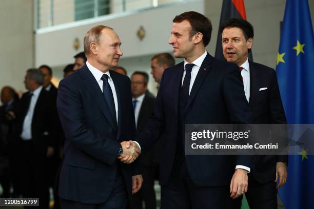 French President Emmanuel Macron greets Russian President Vladimir Putin as they arrive for a family picture at the Chancellery on January 19, 2020...