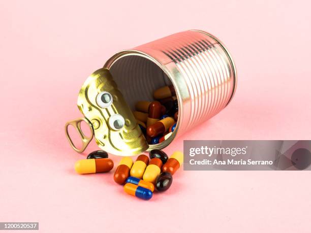 concept of drug contamination. an open tin can with eyes full of colored pills - human representation stock pictures, royalty-free photos & images