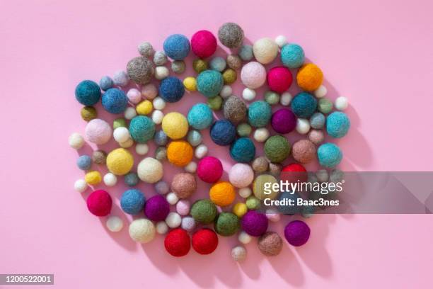 colorful wool/felt balls on pink background - pelote de laine photos et images de collection