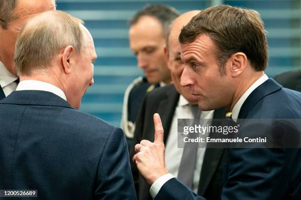 French President Emmanuel Macron speaks with Russian President Vladimir Putin before a meeting at the Chancellery on January 19, 2020 in Berlin,...