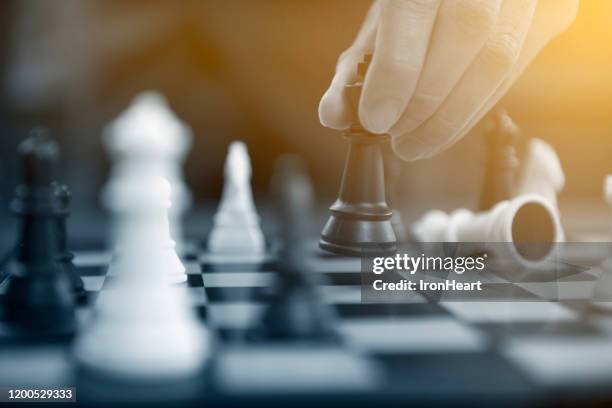 man business concept controling chess, - chess strategy stock pictures, royalty-free photos & images