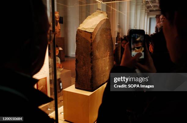 Visitors crowd around the Rosetta Stone in the ancient Egypt section of the British Museum in London. The museum, one of London's top tourist...