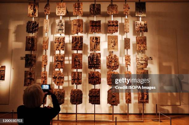 Visitor takes photos of the contentious Benin plaques exhibit at the British Museum in London. The museum, one of London's top tourist attractions,...