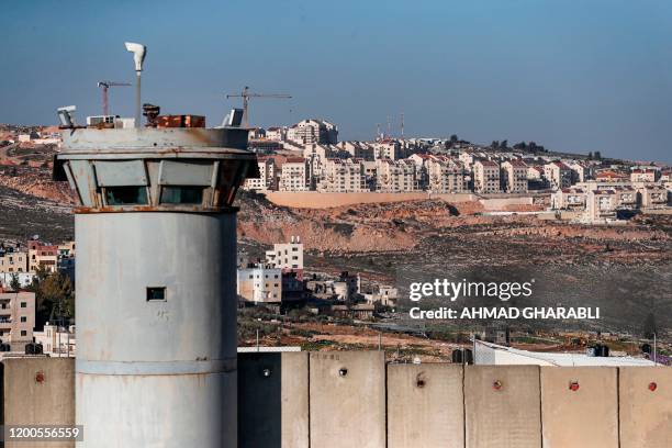 This picture taken on February 13, 2020 shows a view of a watchtower and a section of Israel's controversial separation barrier on the outskirts of...