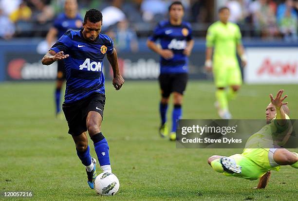 Nani of Manchester United brings the ball up the field as Osvaldo Alonso of the Seattle Sounders FC slides in on him during the first half of the...