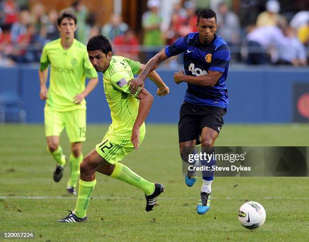 Nani of Manchester United moves around Leo Gonzalez of the Seattle Sounders FC closes in during the first half of the game at CenturyLink Field on...