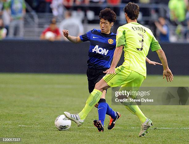 Ji-Sung Park of Manchester United brings the ball up the field against Brad Evans of the Seattle Sounders FC during the second half of the game at...