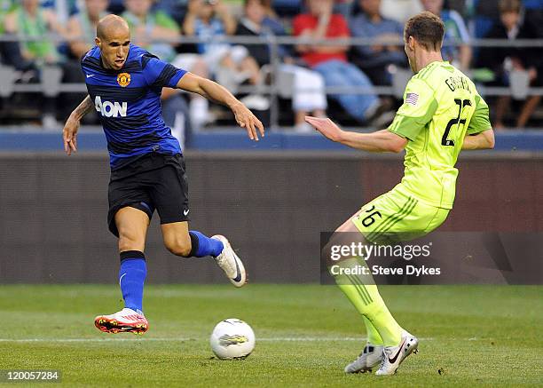 Gabriel Obertan of Manchester United passes the ball on Taylor Graham of the Seattle Sounders FC during the second half of the game at CenturyLink...
