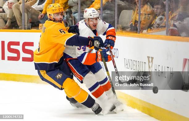 Dan Hamhuis of the Nashville Predators battles for the puck against Cole Bardreau of the New York Islanders at Bridgestone Arena on February 13, 2020...