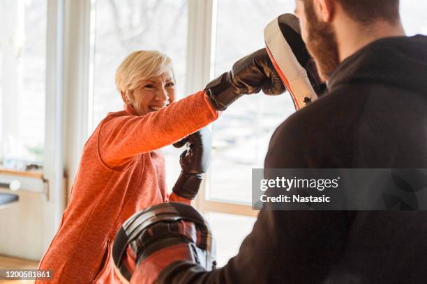 formation de femmes aînées avec l'instructeur au gymnase de boxe - boxe femme photos et images de collection