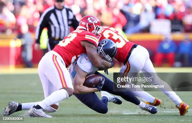 Adam Humphries of the Tennessee Titans is tackled by Anthony Hitchens and Tyrann Mathieu of the Kansas City Chiefs in the first quarter in the AFC...