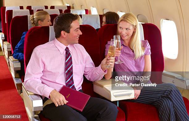 business couple celebrating on plane - first class plane stock-fotos und bilder