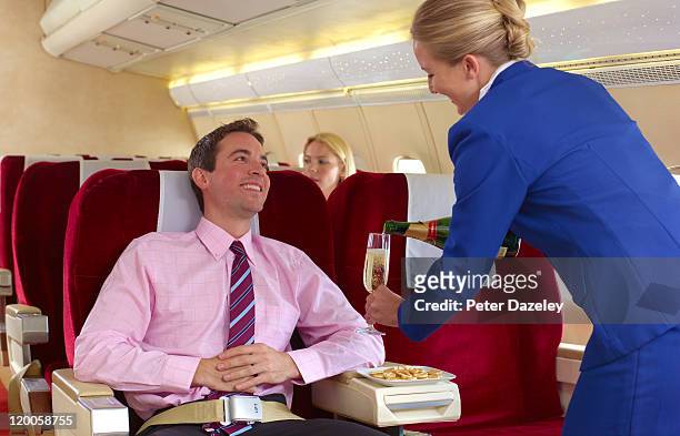 air hostess pouring champagne in first class - first class plane stockfoto's en -beelden