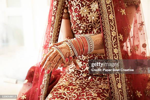 bride putting on her red glass bracelets - indian bride stock-fotos und bilder