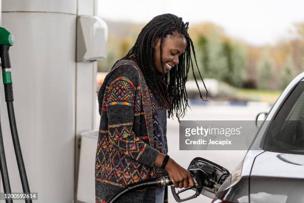vrouw op het tankstation tanken auto - filling stockfoto's en -beelden