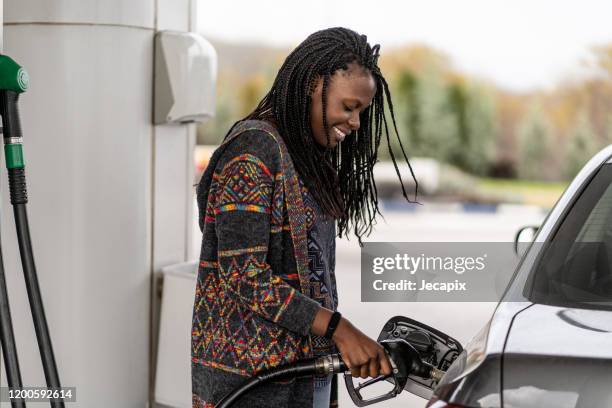 woman at the gas station refueling car - filling stock pictures, royalty-free photos & images