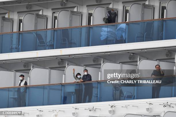 Passengers look out from their balconies on the Diamond Princess cruise ship, with around 3,600 people quarantined onboard due to fears of the new...