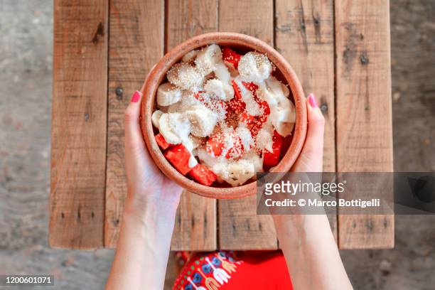 personal perspective of woman holding a fruit bowl with papaya and banana, mexico - mexican rustic stock pictures, royalty-free photos & images
