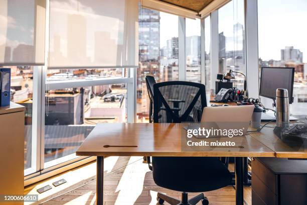 uitzicht op moderne lege kantoorruimte met stad op de achtergrond - leeg bureau stockfoto's en -beelden
