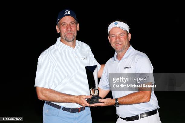 Diamond Resorts CEO Michael Flaskey presents former MLB pitcher John Smoltz with the trophy after winning the celebrity division of the Diamond...