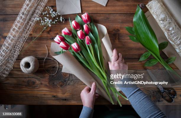 vrouw die een boeket van tulpen maakt - tulips stockfoto's en -beelden