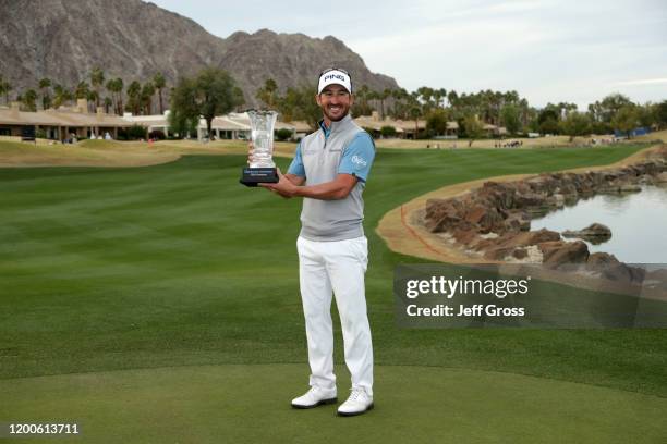 Andrew Landry poses with the trophy on the 18th green during the final round of The American Express tournament at the Stadium Course at PGA West on...