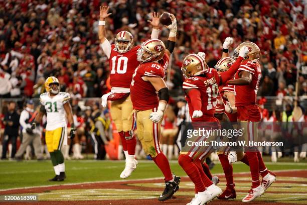 Jimmy Garoppolo and Ben Garland of the San Francisco 49ers celebrate a touchdown in the second quarter against the Green Bay Packers during the NFC...