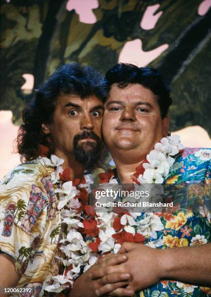 British actors Billy Connolly and Robbie Coltrane wearing Hawaiian shirts and leis, circa 1990.