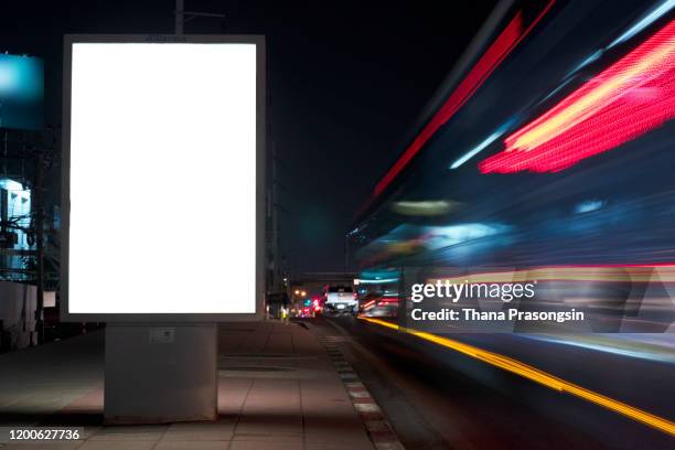 blank billboard on city street at night. outdoor advertising - bus stop poster stock pictures, royalty-free photos & images