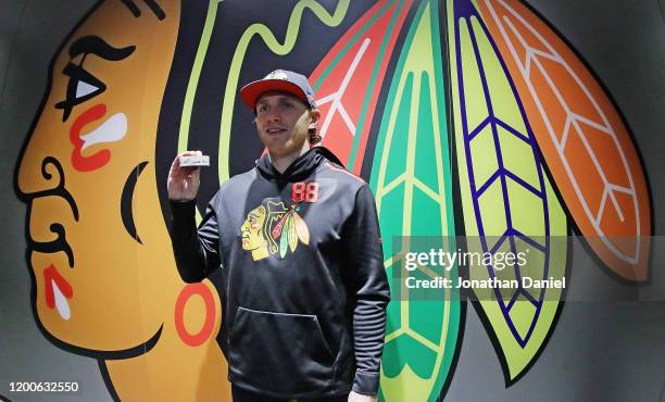 Patrick Kane of the Chicago Blackhawks displays the puck that was used on his 1000th career point, an assist on a goal by Brandon Saad, against the...