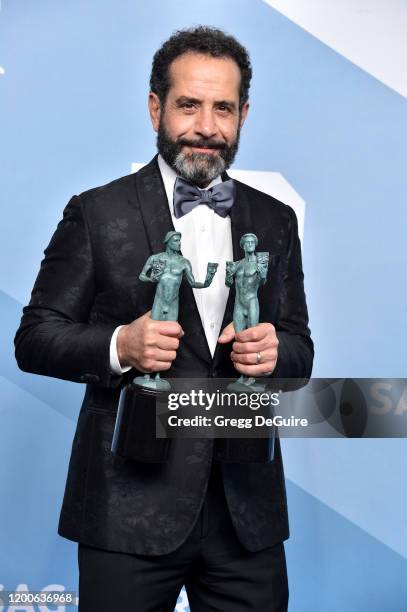 Tony Shalhoub poses in the press room with the trophies for Outstanding Performance by a Male Actor in a Comedy Series and Outstanding Performance by...