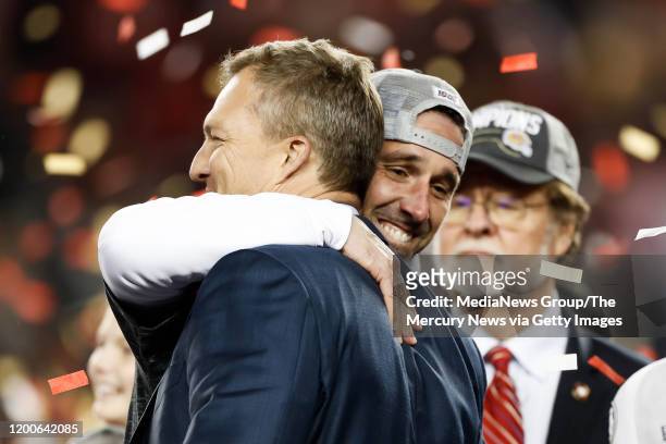 San Francisco 49ers head coach Kyle Shanahan, right, hugs general manager John Lynch, left, after winning the NFC Championship game versus the Green...
