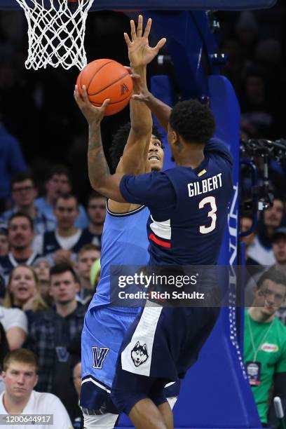 Jeremiah Robinson-Earl of the Villanova Wildcats in action against Alterique Gilbert of the Connecticut Huskies during a college basketball game at...
