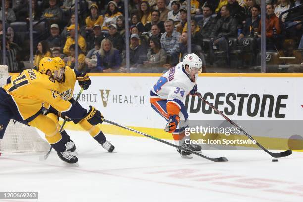 Nashville Predators defenseman Jarred Tinordi and winger Calle Jarnkrok defend against New York Islanders center Cole Bardreau during the NHL game...