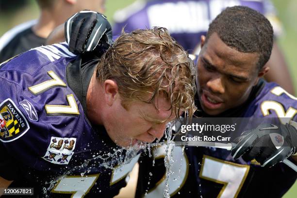 Running back Ray Rice of the Baltimore Ravens and center Matt Birk get a drink during training camp on July 29, 2011 in Owings Mills, Maryland.