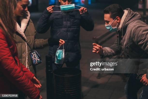 people throwing pollution masks in bin - chilly bin stock pictures, royalty-free photos & images