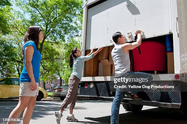 yound adults opening back of moving truck - verhuiswagen stockfoto's en -beelden