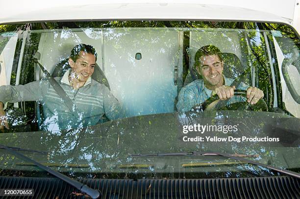 view through windshield of 2 men drivng truck - windschutzscheibe stock-fotos und bilder