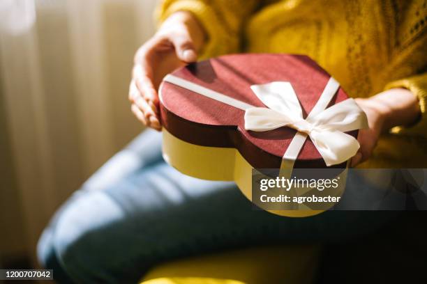 mujer joven sosteniendo caja de regalo del día de san valentín - valentines day fotografías e imágenes de stock