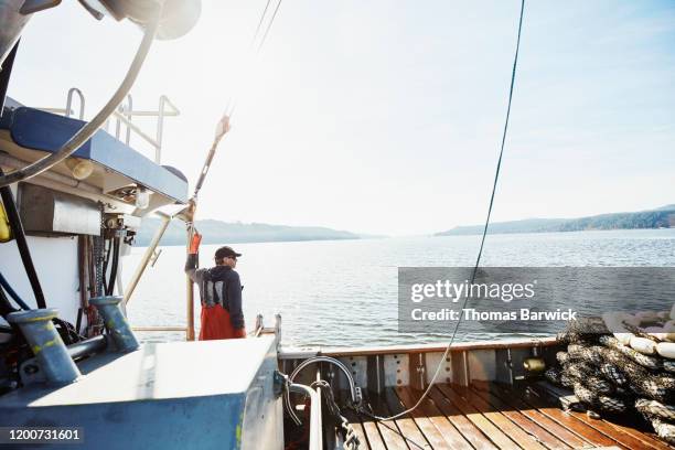 captain of purse seiner looking out from deck of boat - fischerboot stock-fotos und bilder