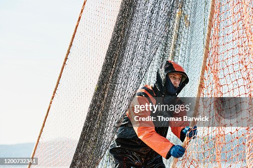 Man In Rain Gear Hauling Net On Commercial Fishing Boat While Fishing For  Salmon High-Res Stock Photo - Getty Images
