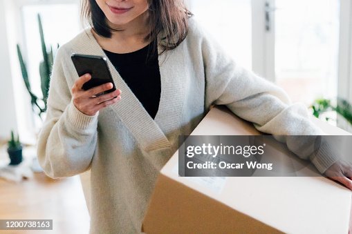Smiling woman receiving parcel at home Smiling woman receiving parcel at home